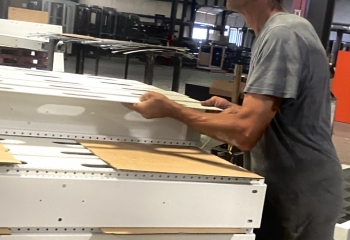 Man stacking white corner strips on a pallet.